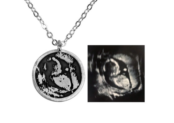 Sterling silver necklace with a silhouette of a baby in an ultrasound, shown with the original ultrasound image